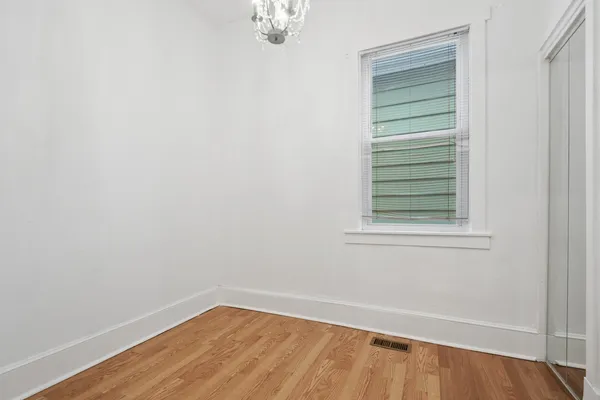 a view of a small space with wooden floor and a window