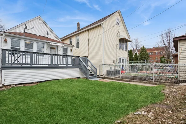 a view of a house with a yard and deck