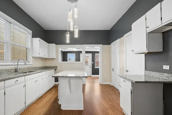 a kitchen with granite countertop a sink stainless steel appliances and cabinets