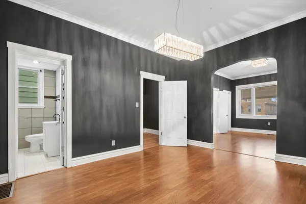 a view of a hallway with wooden floor and a living room