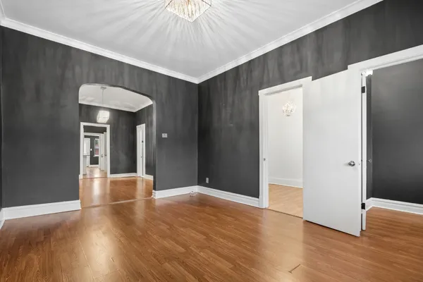 a view of a hallway with wooden floor and chandelier