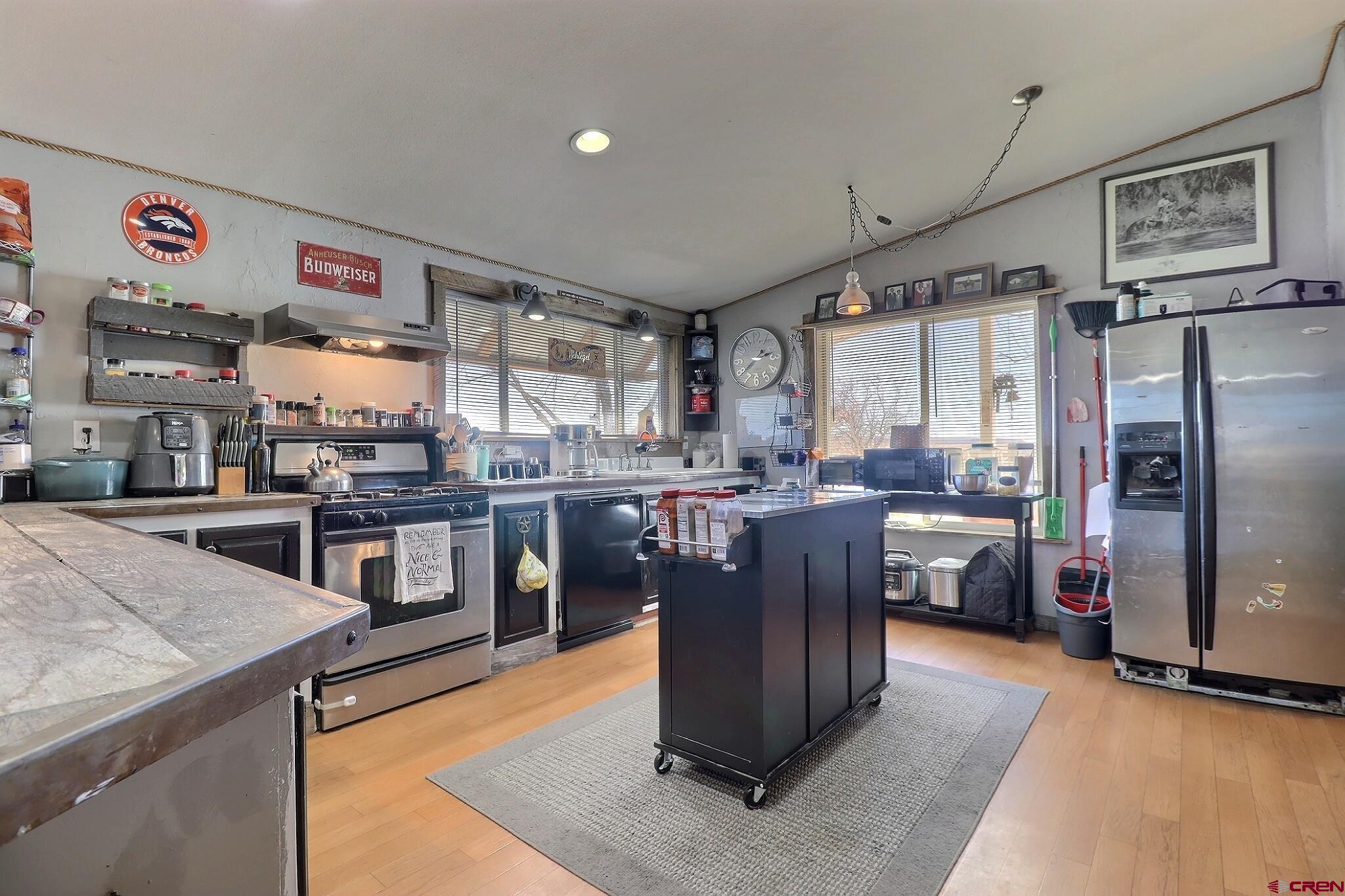 34607 F50 Road Hotchkiss, CO 81419 - Photo 23 of 35 a kitchen with stainless steel appliances granite countertop a refrigerator a stove and a sink with wooden floor