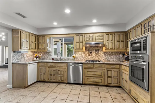 a kitchen with stainless steel appliances granite countertop a stove sink and cabinets