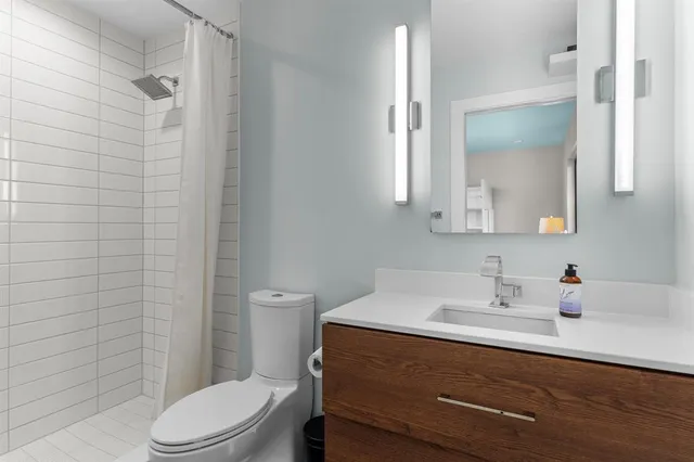 a bathroom with a sink a toilet and shower