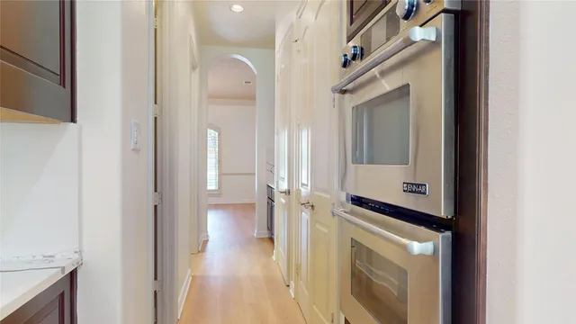 a view of a hallway with wooden floor and staircase