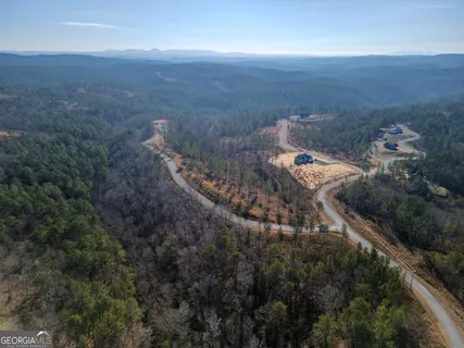 an aerial view of house with yard and mountain view in back