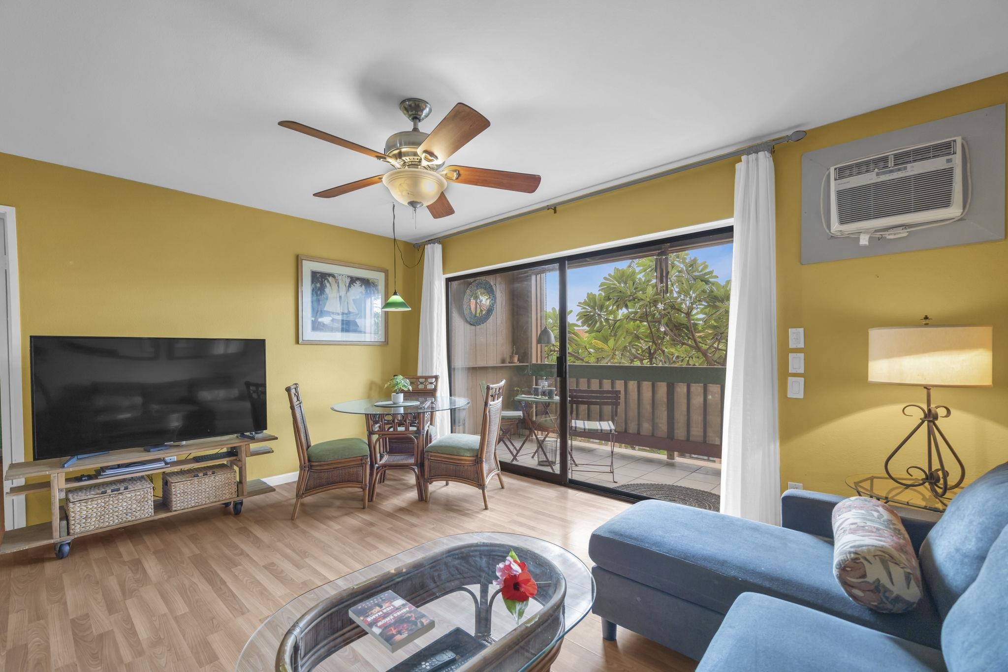 3740 Lower Honoapiilani Road, Unit C205 Lahaina, HI 96761 - Photo 19 of 28 a living room with furniture a flat screen tv and a floor to ceiling window