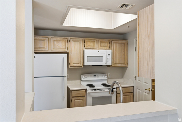 900 Bitner Road, Unit P20 Park City, UT 84098 - Photo 15 of 42 Kitchen featuring light wood cabinetry, white appliances, a contemporary pull-down faucet, solid surface countertops, and a ceiling light panel