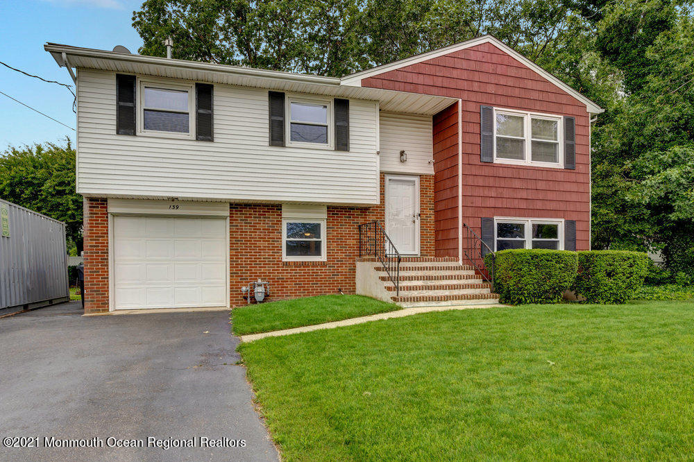 139 Queen Ann Road Brick, NJ 08723 - Photo 2 of 35 a front view of a house with a yard and garage