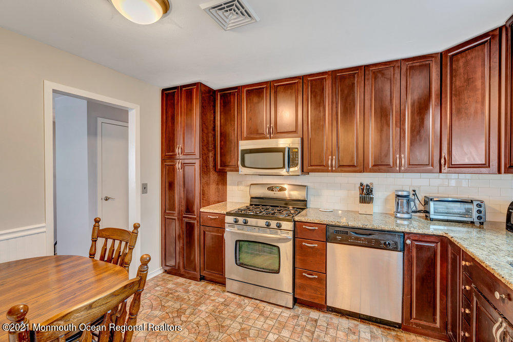 139 Queen Ann Road Brick, NJ 08723 - Photo 12 of 35 a kitchen with granite countertop a stove top oven microwave and cabinets