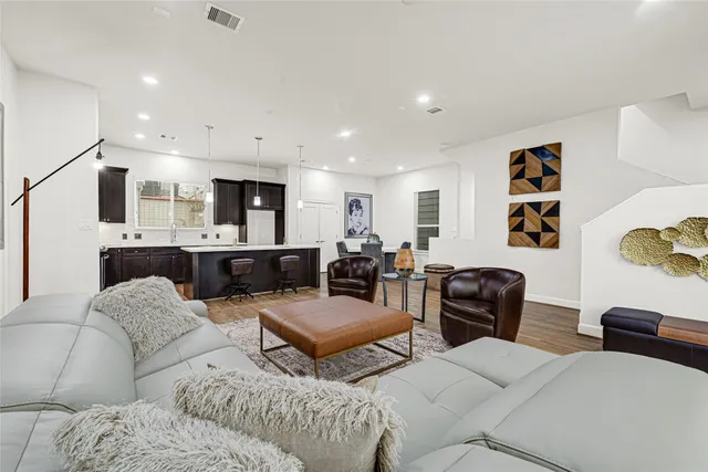 a living room with furniture and a view of kitchen