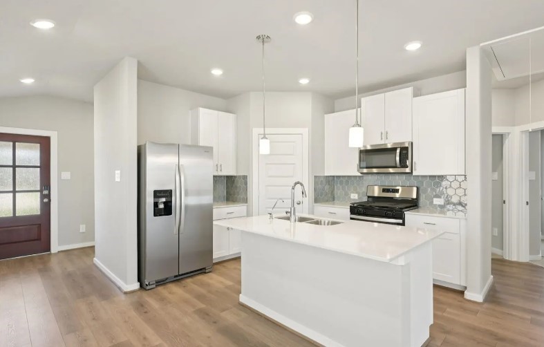 a kitchen with stainless steel appliances a refrigerator sink and microwave