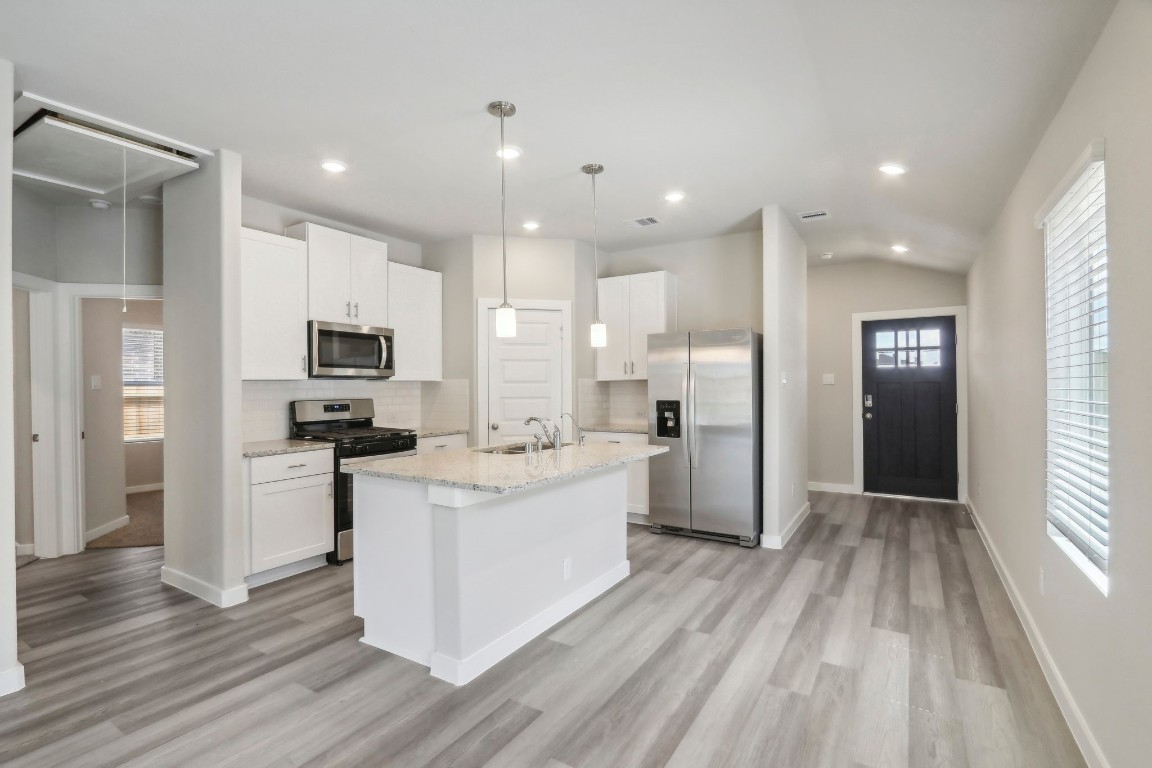 14174 Granger Pointe Lane Conroe, TX 77302 - Photo 2 of 9 a kitchen with white cabinets and stainless steel appliances