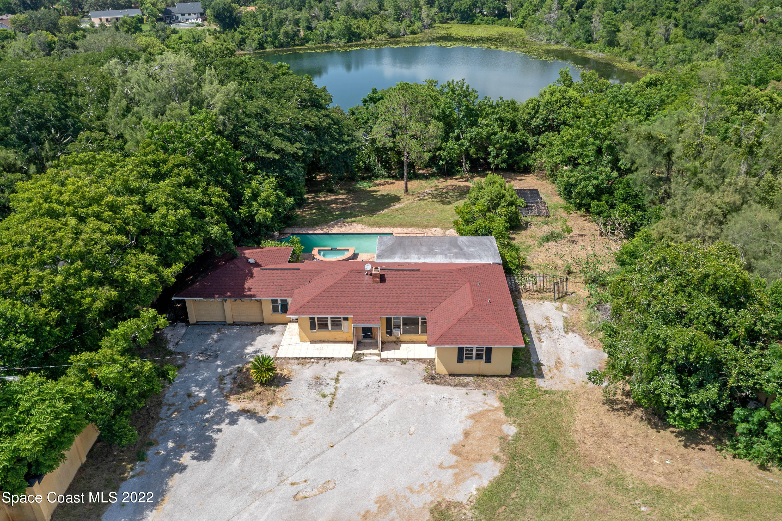 an aerial view of a house with a yard and lake view