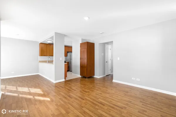 a view of an empty room with wooden floor and closet