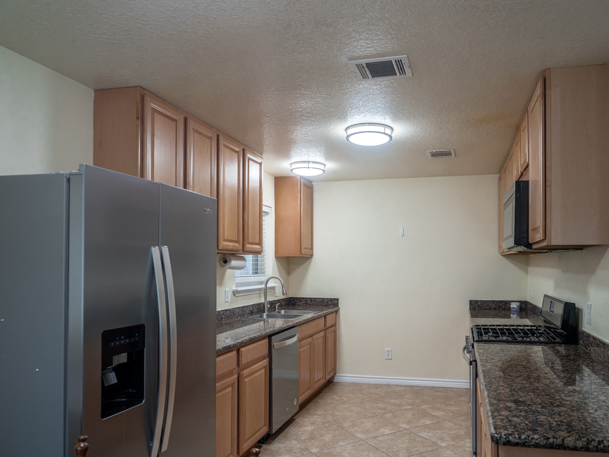3302 Willie Way Spring, TX 77380 - Photo 3 of 28 a kitchen with stainless steel appliances granite countertop a refrigerator a stove and a sink