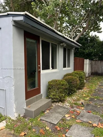 a view of a yard with plants and a bench
