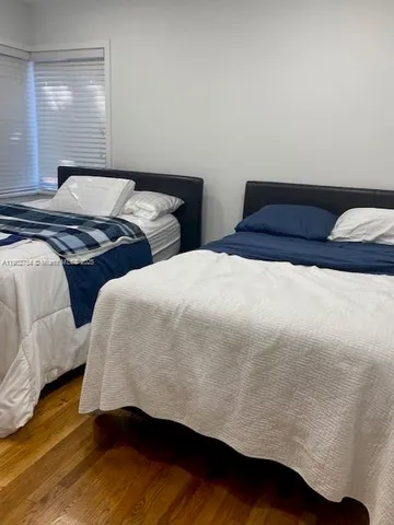 a bedroom with two bed and a night stand