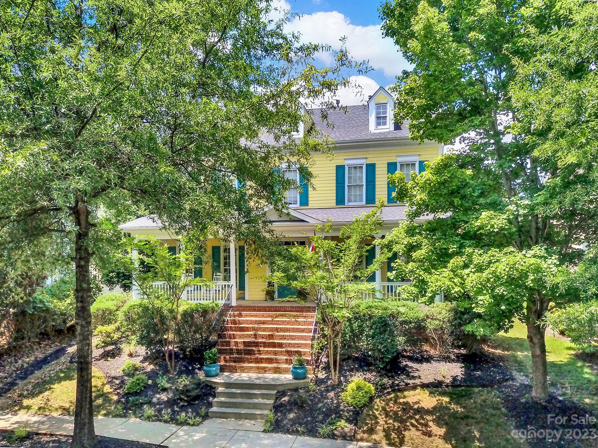 a front view of a house with a yard and potted plants