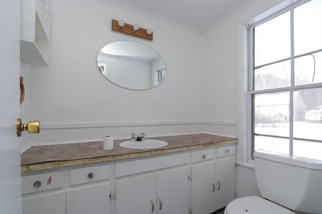 a bathroom with a granite countertop sink a toilet and a mirror