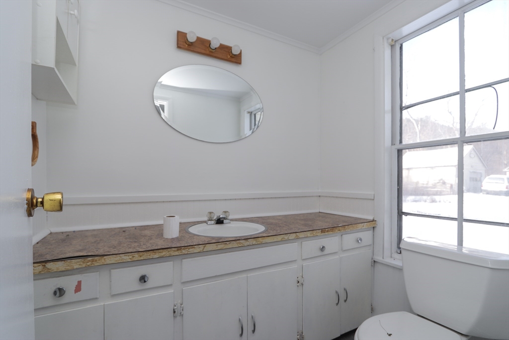 56 Middlefield Road Chester, MA 01011 - Photo 14 of 38 a bathroom with a granite countertop sink a toilet and a mirror