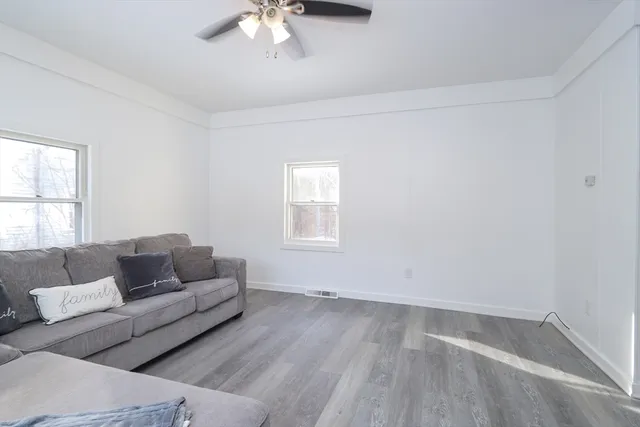 a living room with furniture and a hard wood floor