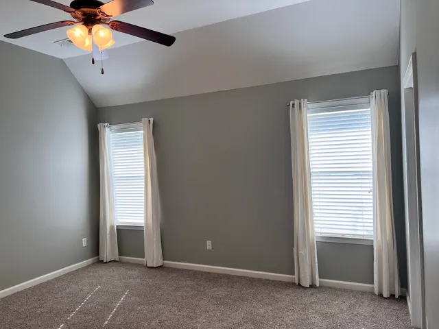 an empty room with window and a ceiling fan
