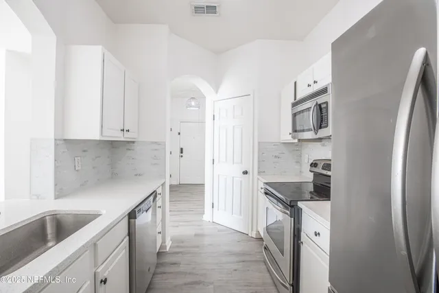 a kitchen with granite countertop a sink stove and refrigerator