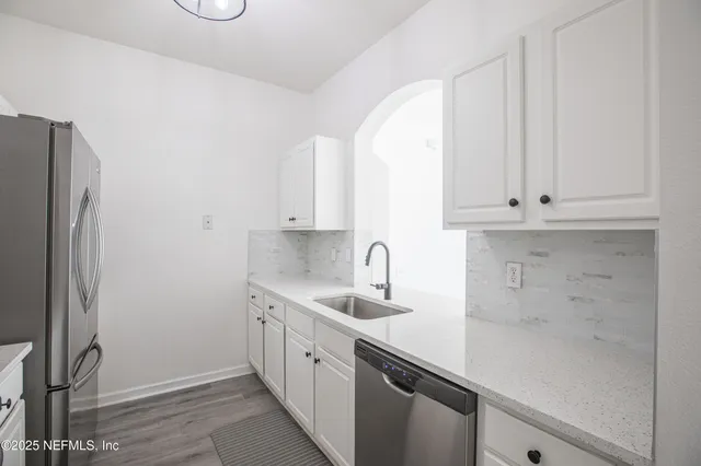 a kitchen with stainless steel appliances granite countertop white cabinets and a refrigerator