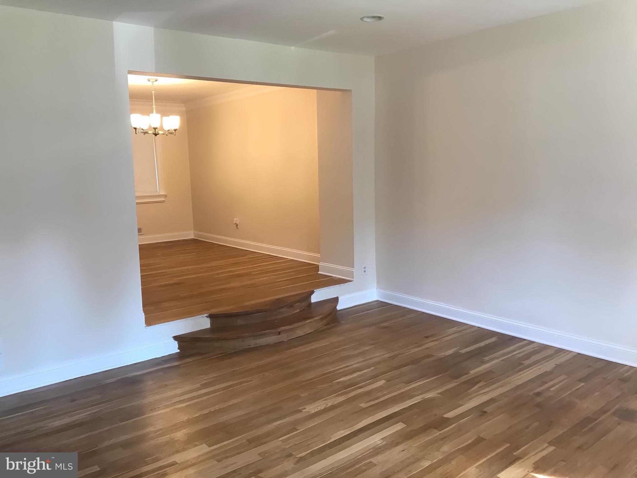 1713 Stokesley Road Baltimore, MD 21222 - Photo 2 of 15 an empty room with wooden floor and windows