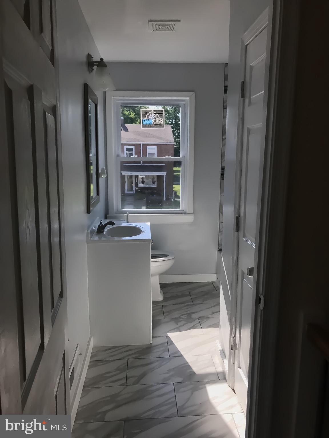 1713 Stokesley Road Baltimore, MD 21222 - Photo 11 of 15 a view of a hallway with wooden floor and a living room