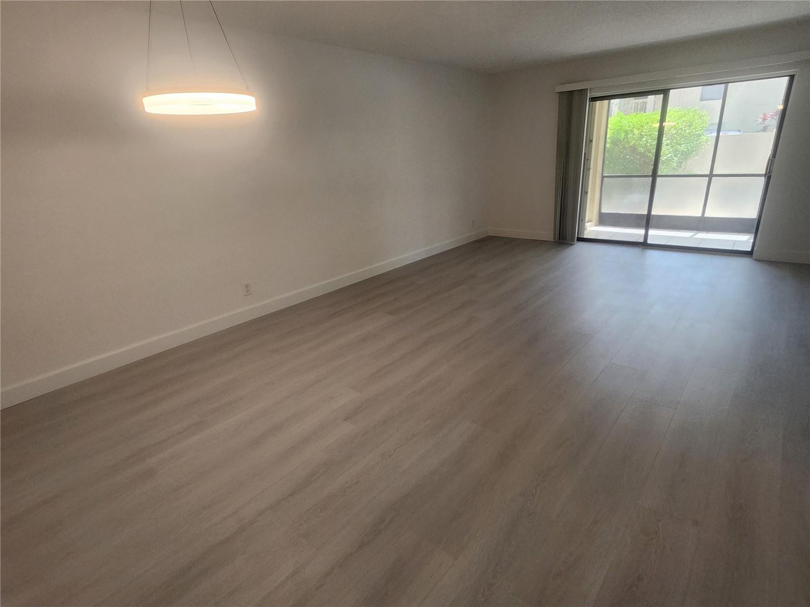 138 South Cypress Road, Unit 217 Pompano Beach, FL 33060 - Photo 15 of 21 an empty room with wooden floor and windows