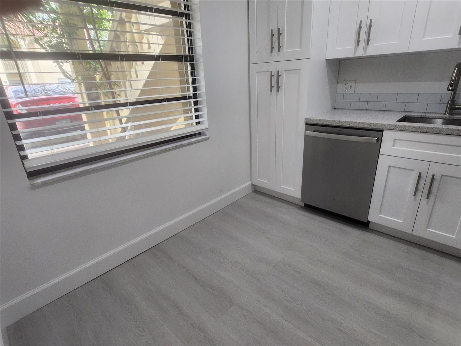 138 South Cypress Road, Unit 217 Pompano Beach, FL 33060 - Photo 5 of 21 an empty room with wooden floor and windows