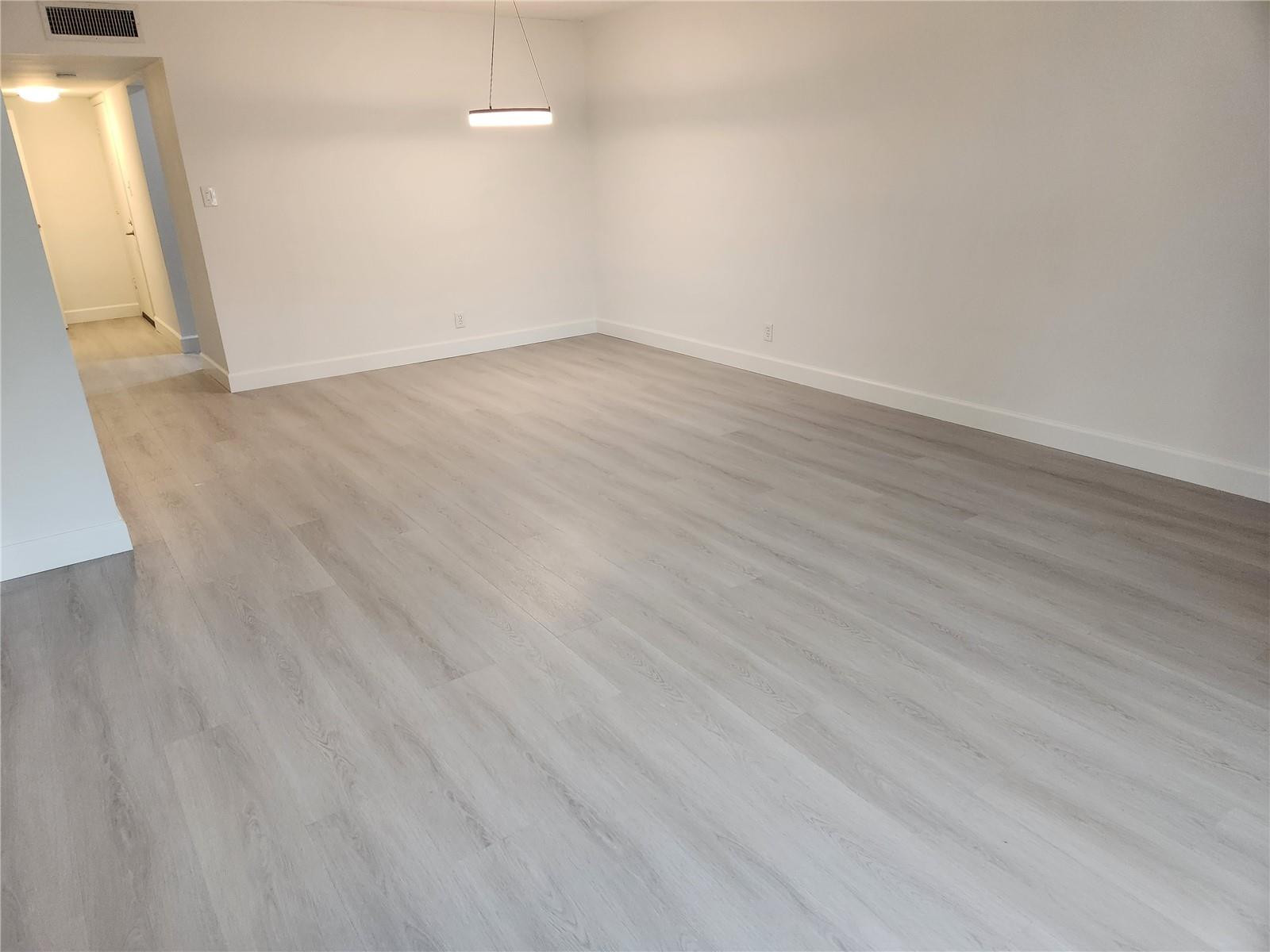 138 South Cypress Road, Unit 217 Pompano Beach, FL 33060 - Photo 6 of 21 an empty room with wooden floor and windows