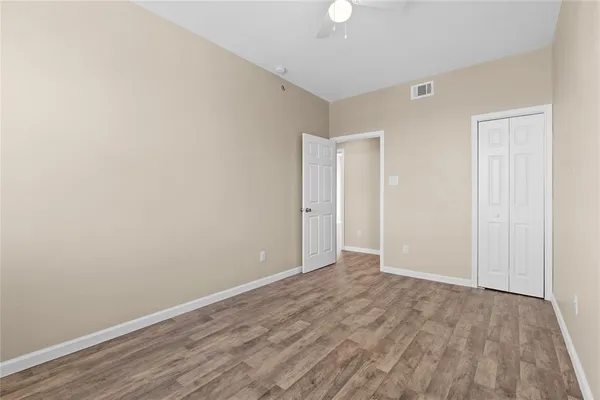 a view of an empty room with wooden floor