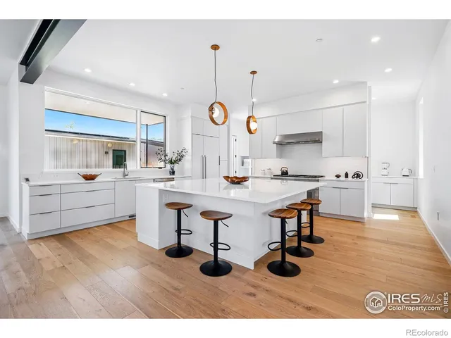 a kitchen with stainless steel appliances kitchen island a sink cabinets and wooden floor