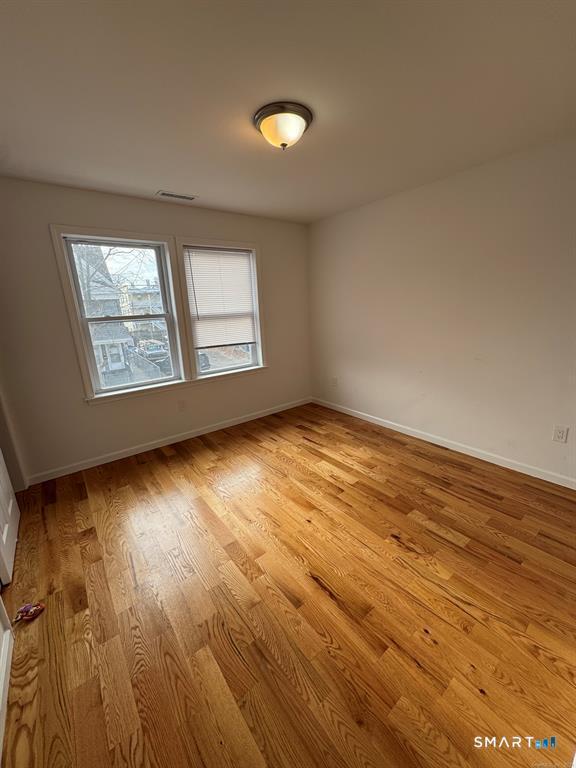 695 Shelton Street Bridgeport, CT 06608 - Photo 17 of 36 an empty room with wooden floor and windows