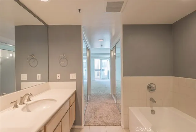 a bathroom with a tub sink and mirror