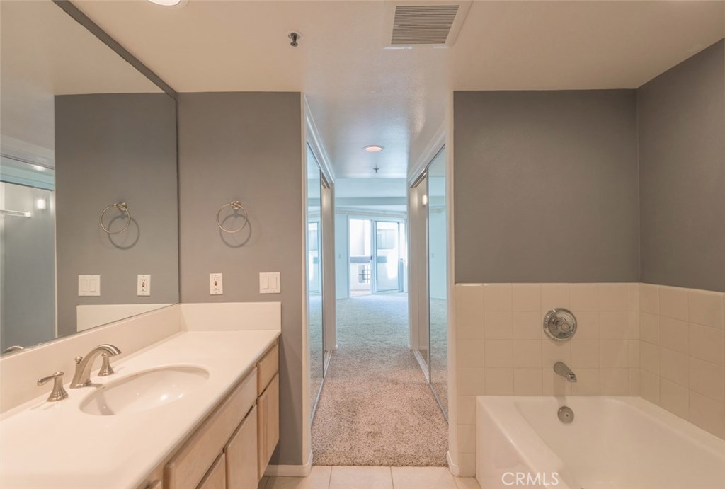200 Pacific Coast Highway, Unit 314 Huntington Beach, CA 92648 - Photo 11 of 26 a bathroom with a tub sink and mirror
