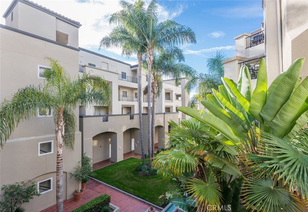 200 Pacific Coast Highway, Unit 314 Huntington Beach, CA 92648 - Photo 13 of 26 a front view of multi story residential apartment building with yard and outdoor seating