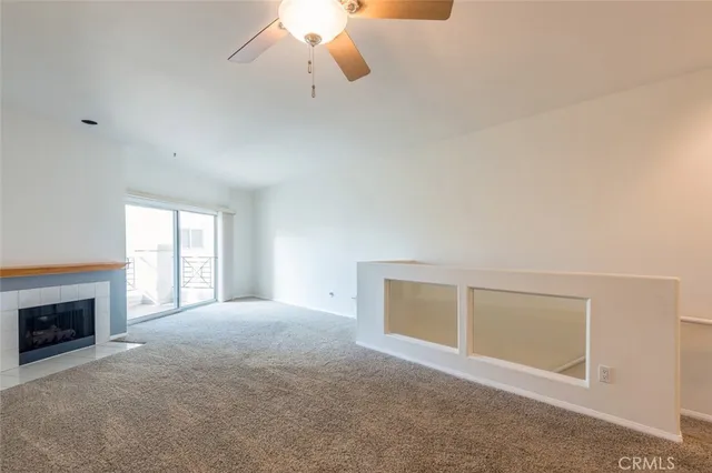a view of an empty room with a fireplace and a window
