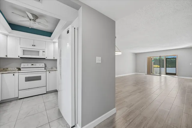 a kitchen with granite countertop white cabinets sink and white appliances