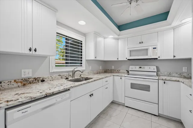 a kitchen with granite countertop cabinets sink and window