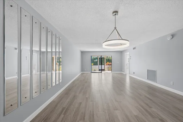 a view of a room with wooden floor swimming pool and windows