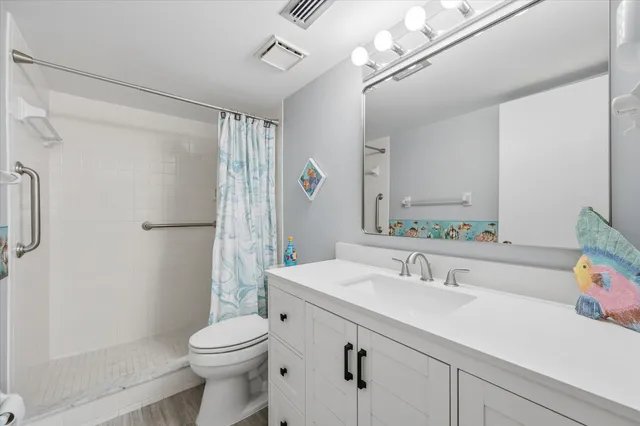 a view of an empty room with wooden floor and closet