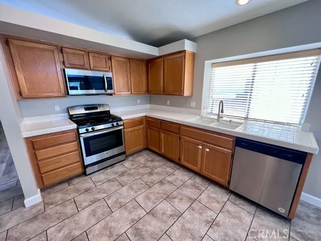 a kitchen with stainless steel appliances granite countertop a sink stove and microwave