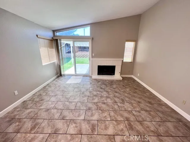 a view of empty room with a fireplace and window