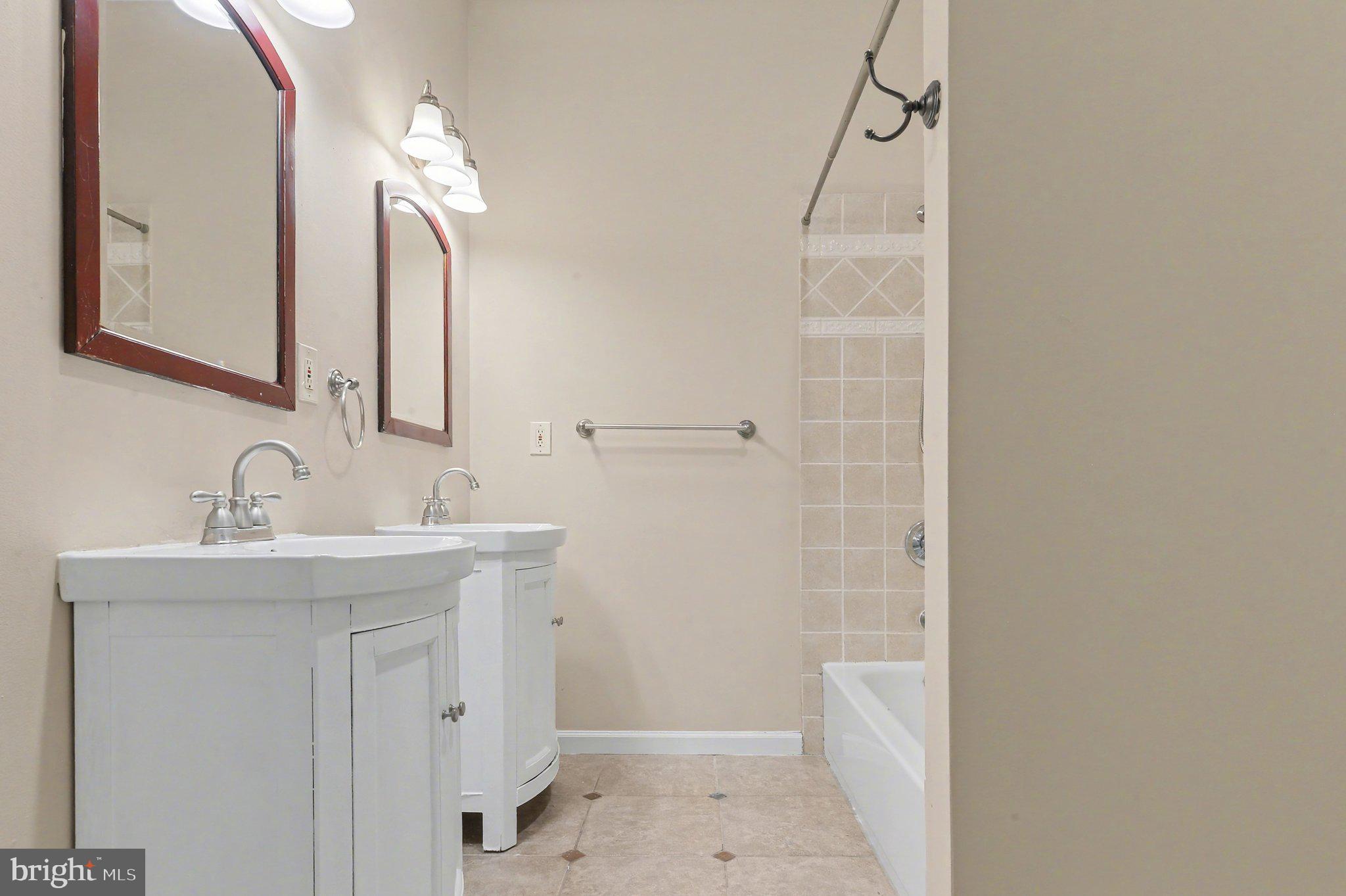 3418 East Baltimore Street Baltimore, MD 21224 - Photo 21 of 40 a bathroom with a sink a toilet a mirror and shower