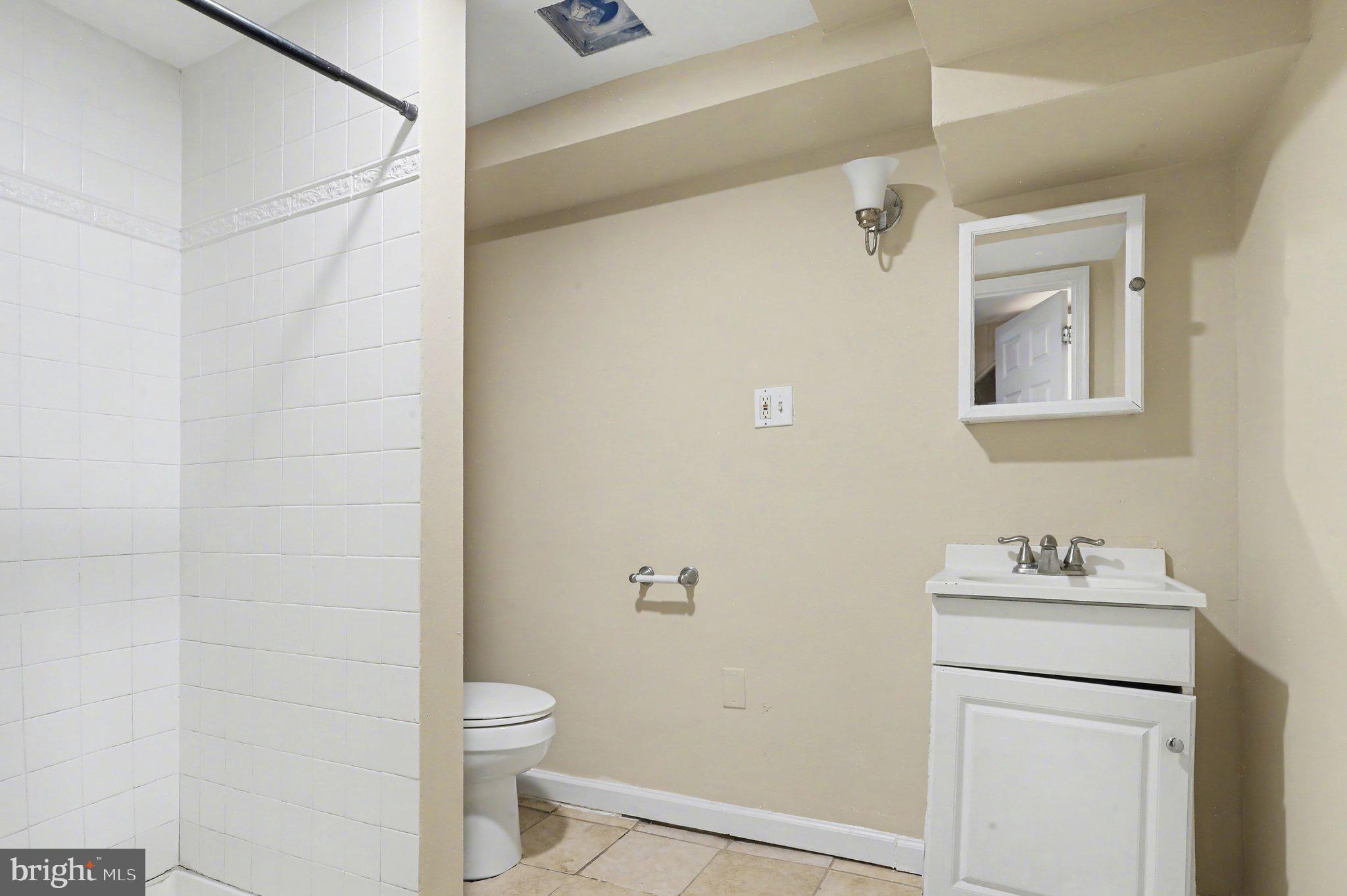 3418 East Baltimore Street Baltimore, MD 21224 - Photo 36 of 40 a bathroom with a toilet sink vanity and mirror