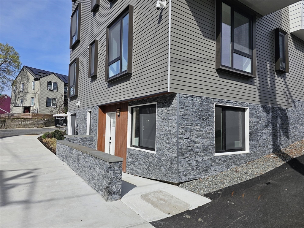 64 Alpine Street, Unit 104 Boston, MA 02119 - Photo 14 of 15 a front view of a house with yard